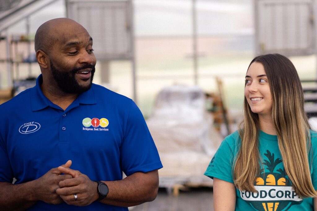 Warren DeShields and Jenny Reed, in front of greenhouse