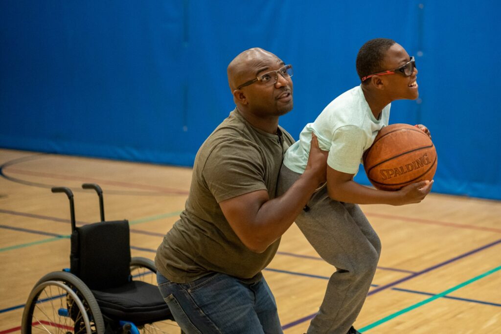 Clayton shooting a basket with dad's help