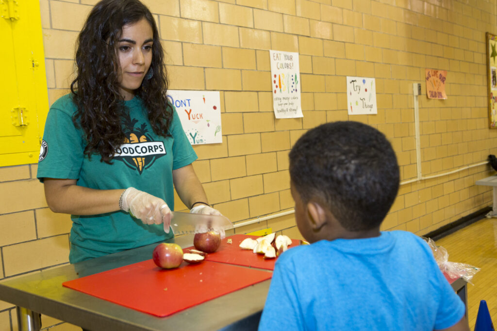 Rachel cuts up an apple for a student