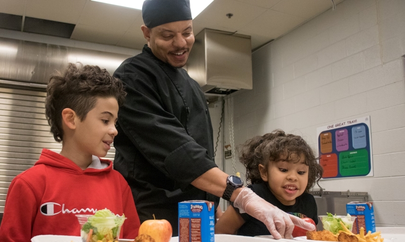 Chef Kevin Frank talking lunch with 2 kids.