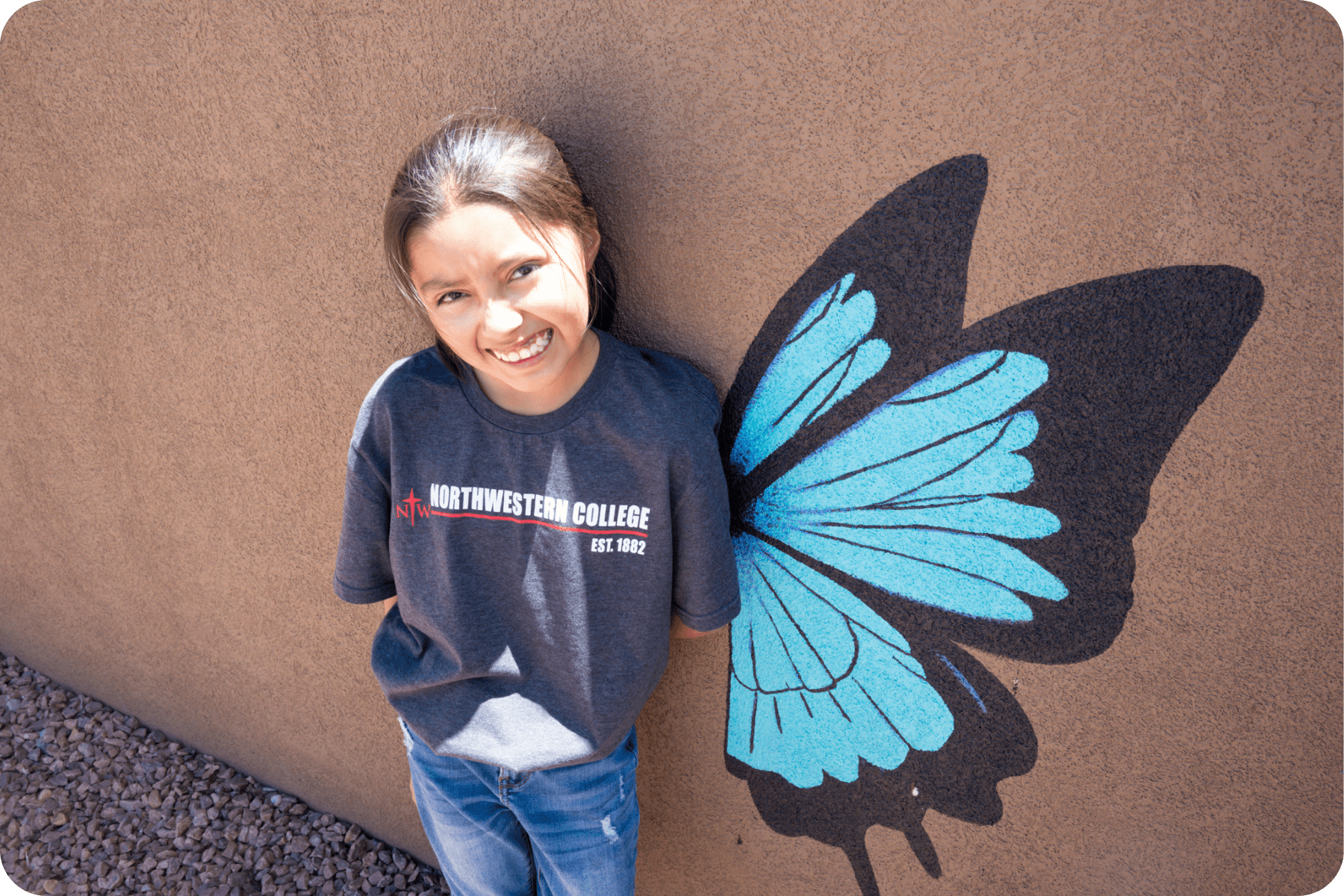 Calista posing in front of butterfly mural
