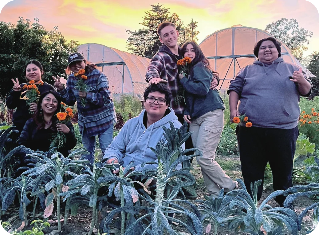 Youth standing in front of greenhouses.