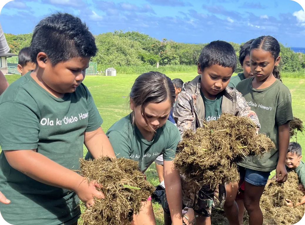 Children gathering grass clippings.