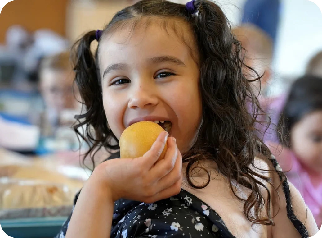 A young child bites into an apple.