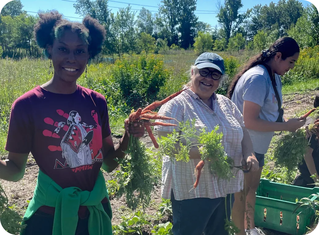 Community members holding carrots.