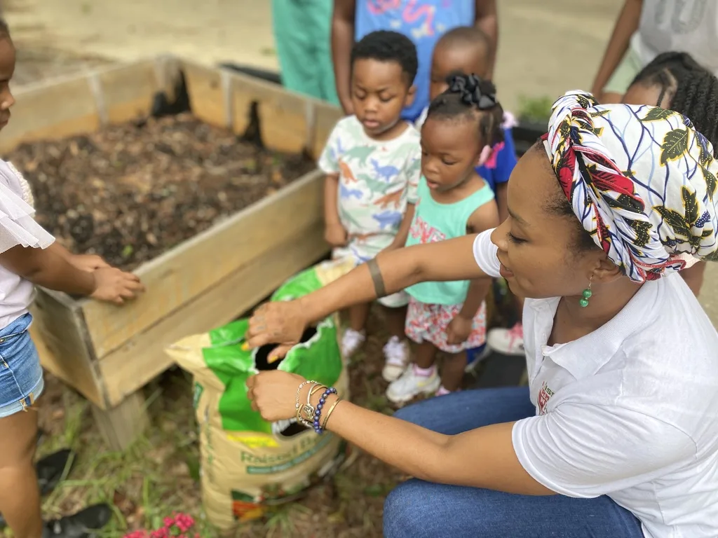 An instructor with dirt and children.