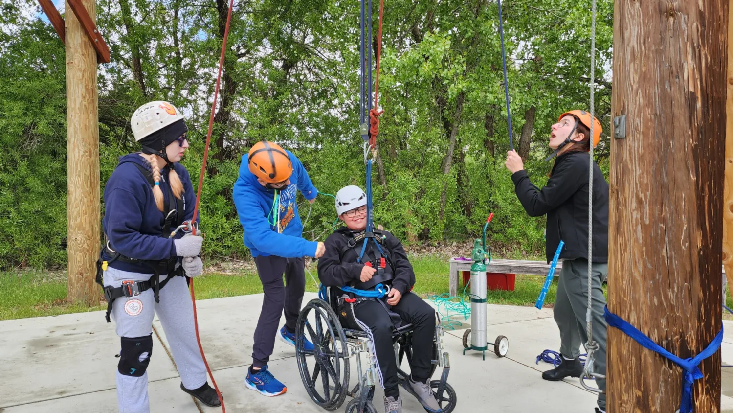 A child in a wheelchair prepares to go on the zip line.