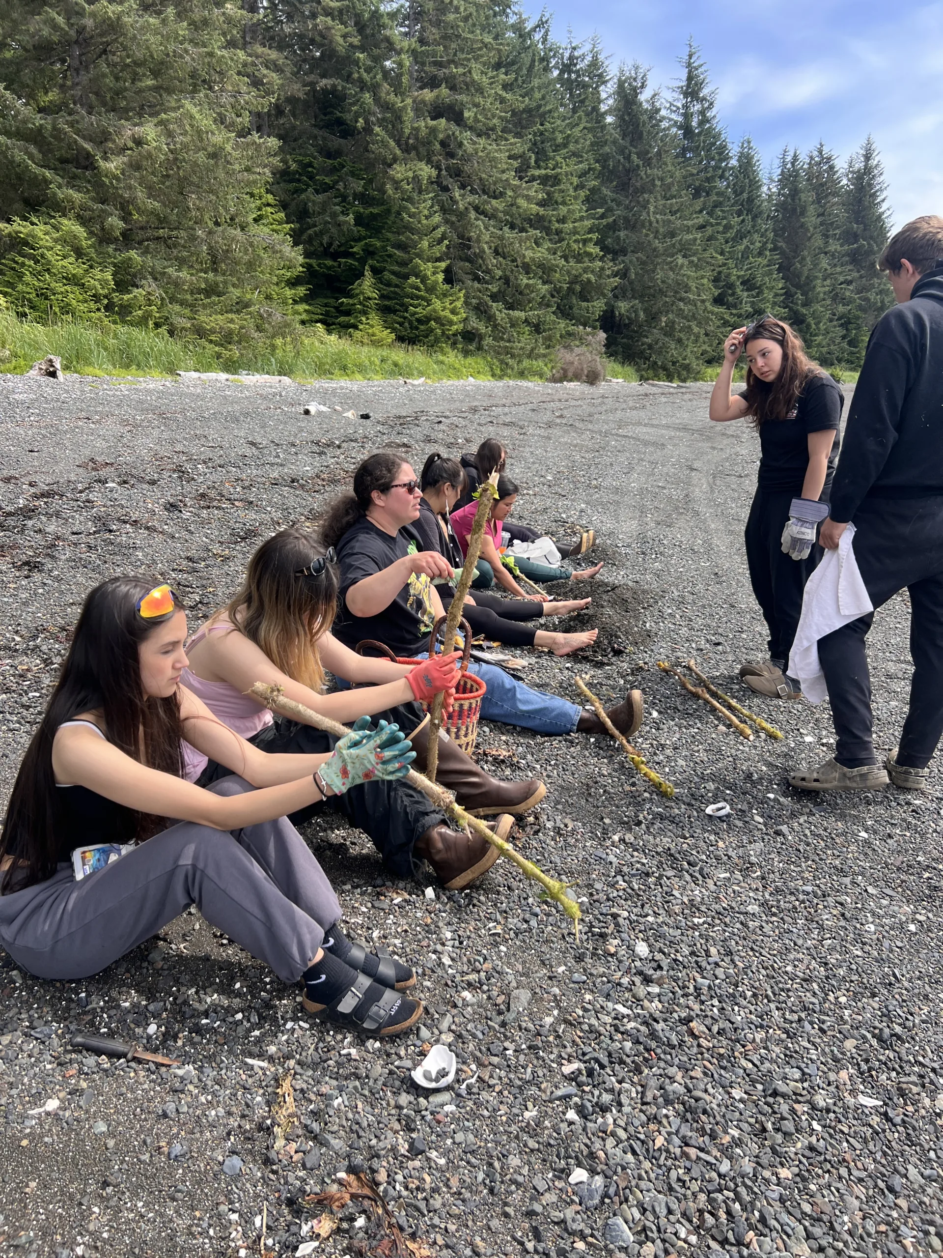 Youth sit on a rocky shore