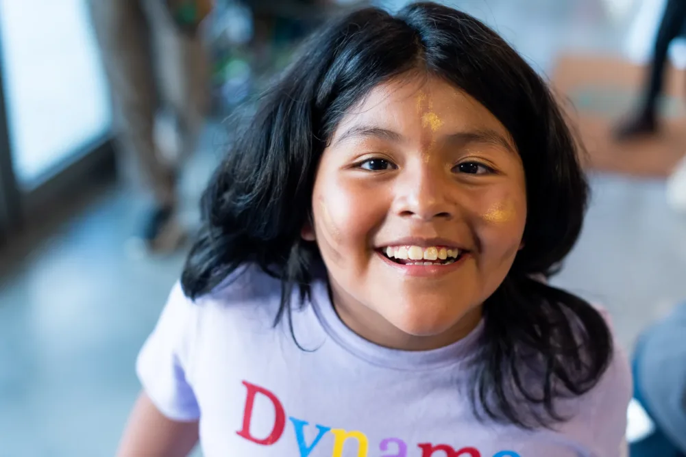 A young camper with glitter face paint